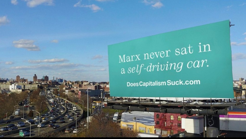 billboard: Marx never sat in a self-driving car. DoesCapitalismSuck.com